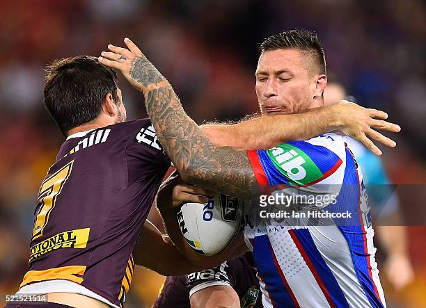 Tariq Sims of the Knights is tackled by Ben Hunt of the Broncos during the round seven NRL match between the Brisbane Broncos and the Newcastle...