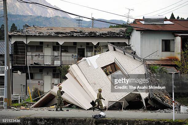 Japan Ground Self-Defense Force walk in front of collapsed buildings as the rescue operation continues on April 16, 2016 in Minamiaso, Kumamoto,...