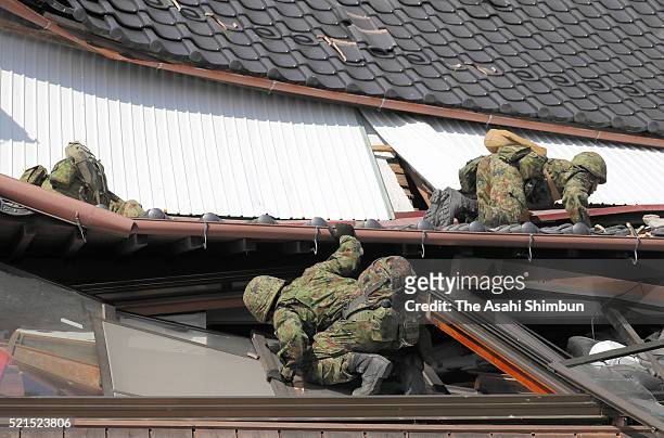Japan Ground Self-Defense Force members check a collapsed house as the rescue operation continues on April 16, 2016 in Minamiaso, Kumamoto, Japan....