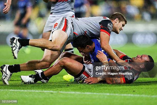 Sam Perrett of the Bulldogs is tackled by Bodene Thompson and Blake Ayshford of the Warriors during the round seven NRL match between the Canterbury...