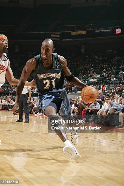 Kevin Garnett of the Minnesota Timberwolves moves the ball against Melvin Ely of the Charlotte Bobcats during the game at Charlotte Coliseum on...