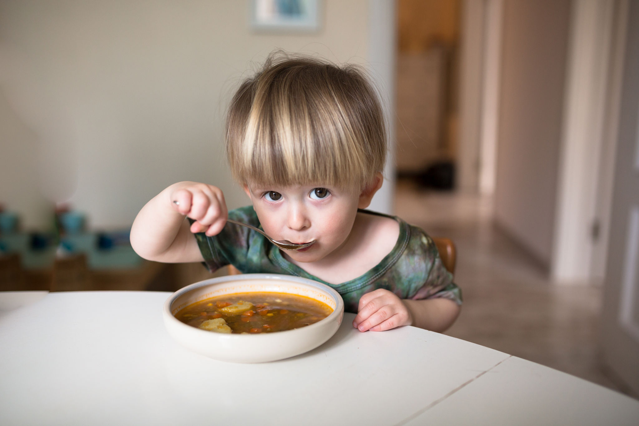 child eating soup