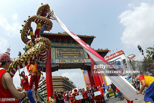 Banner bearing new year greetings in unfurled lion dancers at Odion Circle in Bangkok's Chinatown district, 08 February 2005, ahead of tomorrow's...