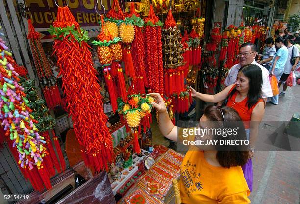 Shoppers buy Chinese good luck charms at Manila's Chinatown 08 February 2005. Shopping among Manila's huge Chinese community has been frenetic ahead...