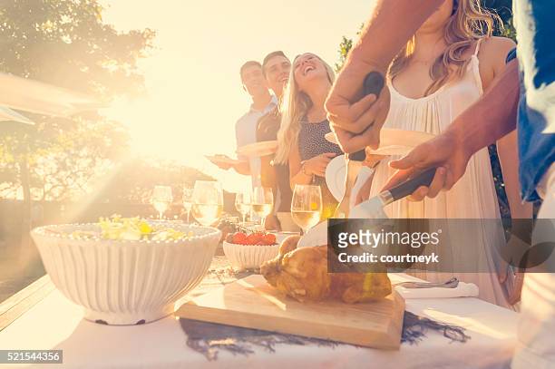carving a chicken with friends and family. - restaurant sydney outside stock pictures, royalty-free photos & images