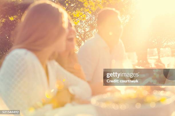 defocussed group of young people eating outdoors. - summer party bildbanksfoton och bilder