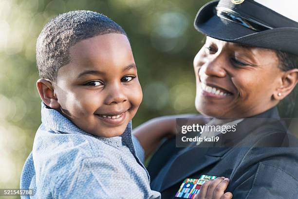 mãe em azul-marinho auditor uniforme segurando seu filho - marinha imagens e fotografias de stock