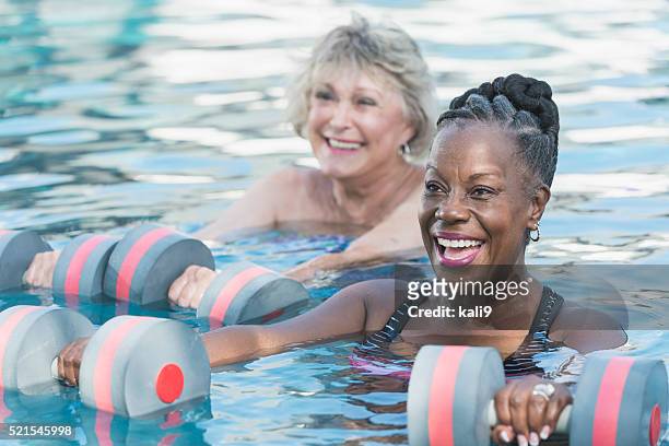 senior black woman and friend doing water aerobics - aquarobics stockfoto's en -beelden