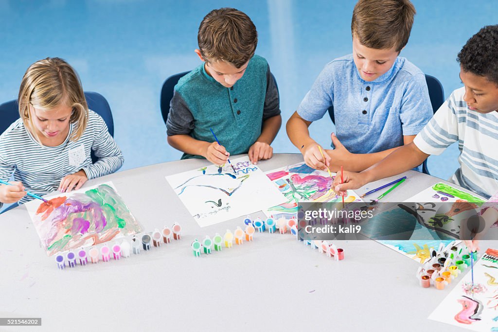 Elementary school children in art class painting