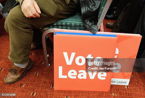 Man sits next to campaign placards as Boris Johnson delivers a speech speech at a 'Vote Leave' rally at the Centre for Life on April 16, 2016 in...