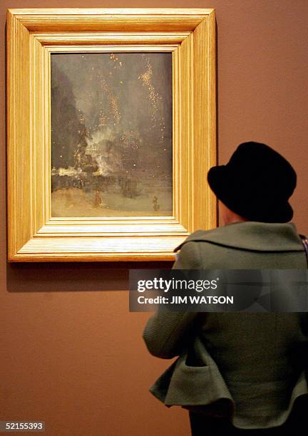 Woman looks at James Abbott McNeill Whistler's "Nocturne in Black and Gold: The Falling Rocket" during the opening of the Turner-Whistler-Monet...