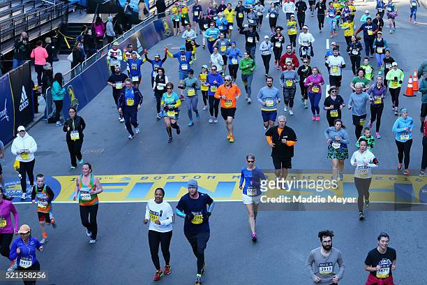 Runners cross the Boston Marathon Finish Line during the 2016 B.A.A. 5k on April 16, 2016 in Boston, Massachusetts.