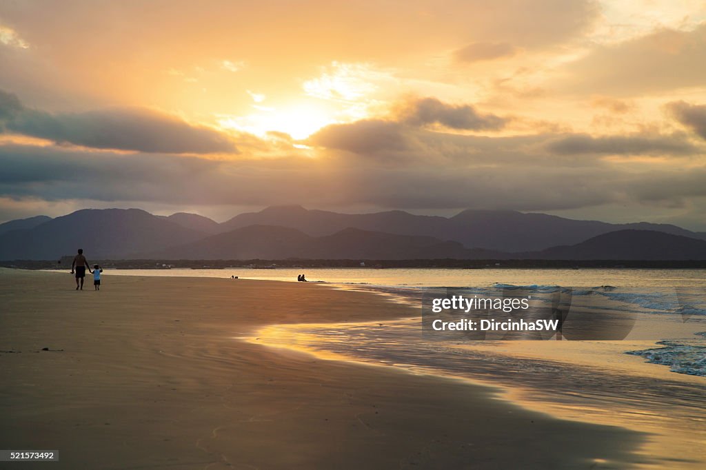 People on beach at sunset.