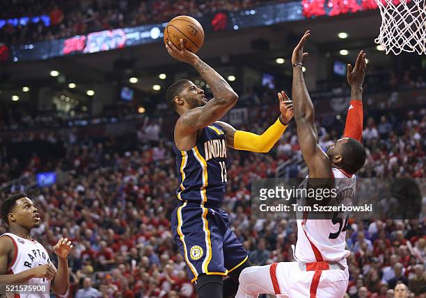 Paul George of the Indiana Pacers shoots against Patrick Patterson of the Toronto Raptors in Game One of the Eastern Conference Quarterfinals during...