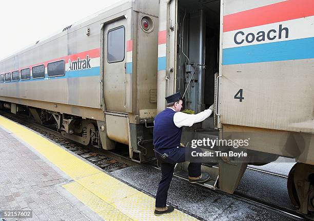 Conductor climbs back onto Amtrak's Hiawatha train from Milwaukee, Wisconsin to Chicago after a stop at the Amtrak station February 8, 2005 in...