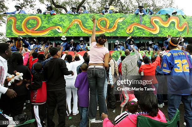 People dressed in blackface toss beads to the crowd during the Zulu parade, a primarily African-American parade, during Mardi Gras festivities...