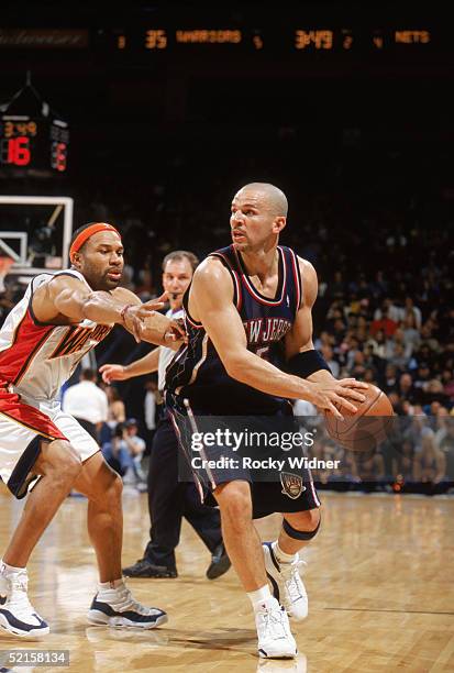 Jason Kidd of the New Jersey Nets looks to move the ball against Derek Fisher of the Golden State Warriors during the game at The Arena in Oakland on...