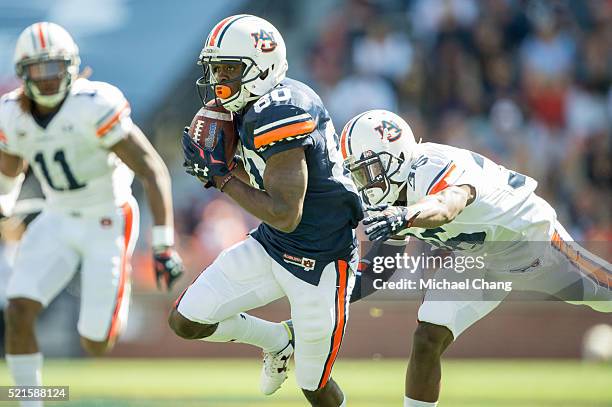 Wide receiver Marcus Davis of the Auburn Tigers avoids a tackle by defensive back Michael Sherwood of the Auburn Tigers after catching a pass during...