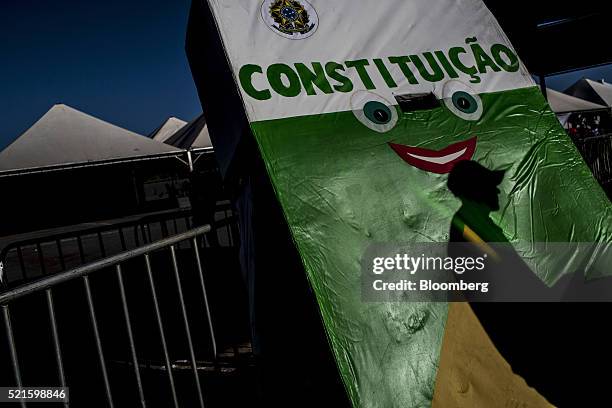 Protester's shadow is cast on mock sculpture representing the Brazilian constitution at a camp site supporting Dilma Rousseff, Brazil's President,...