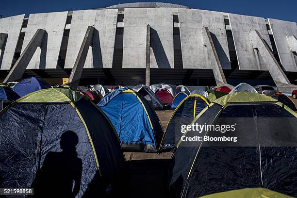 The shadow of a protester is cast on a tent during a camp out in support of Dilma Rousseff, Brazil's President, and the ruling Workers Party in...