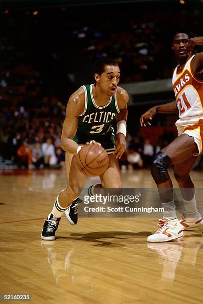 Dennis Johnson of the Boston Celtics drives to the basket against Dominique Wilkins of the Atlanta Hawks during an NBA game in 1986 at the Omni in...
