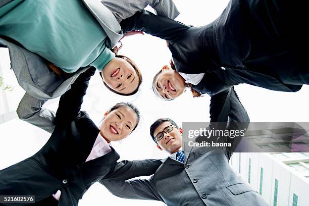 business team forming huddle - group of businesspeople standing low angle view stock pictures, royalty-free photos & images