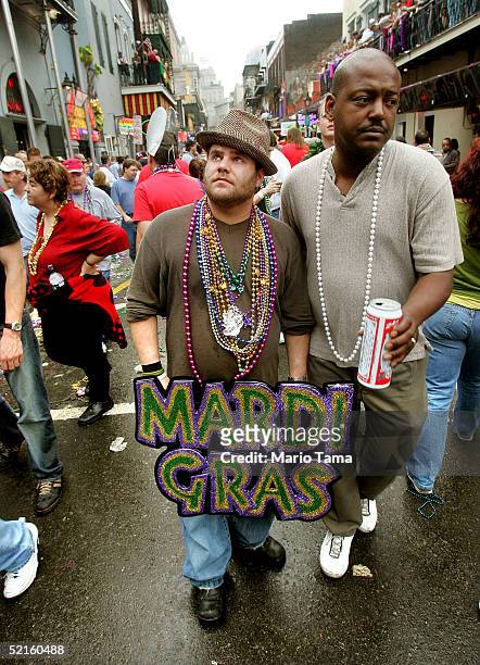 Man holds a Mardi Gras sign on Bourbon Street during Mardi Gras festivities February 8, 2005 in New Orleans, Louisiana. Mardi Gras is the last...