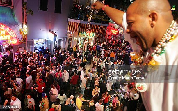 Man offers beads to women crowded on Bourbon Street during Mardi Gras festivities February 8, 2005 in New Orleans, Louisiana. Mardi Gras is the last...