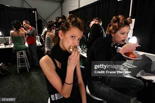 Models take a meal break backstage at the Pamella Roland Fall 2005 show during the Olympus Fashion Week in Bryant Park February 8, 2005 in New York...