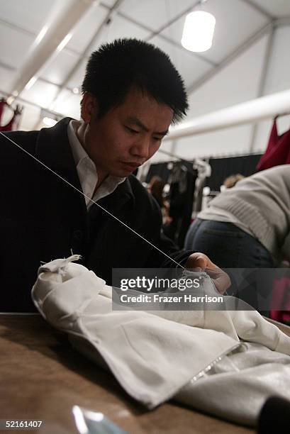 Male seamstress sows backstage at the Narciso Rodriguez Fall 2005 show during the Olympus Fashion Week at Bryant Park February 8, 2004 in New York...