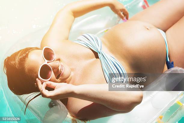 schwangere frau sonnenbaden in bikini lächeln fröhlich von hinter-sonnenbrille - curvy woman swimsuit stock-fotos und bilder
