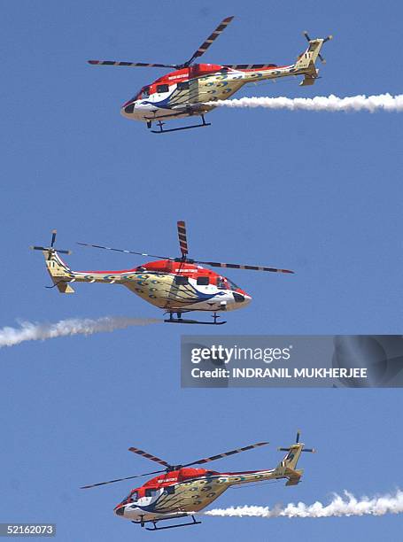 Advanced Light Helicopters of the Indian Air Force's Sarang aerobatics team perform during the inaugural function of the Aero India 2005 airshow at...