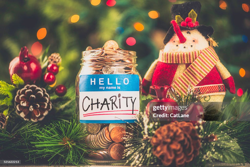 Charity donation jar filled with American currency in holiday setting