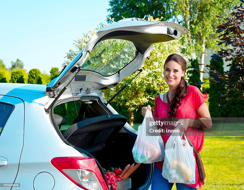 Young woman standing outdoor, holding shopping bags