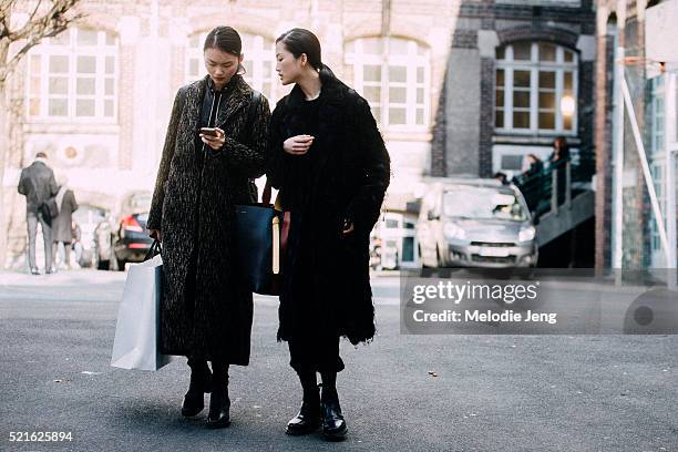 Chinese models Cong He and Jing Wen exit the John Galliano show at Lycee Carnot on Day 6 of PFW FW16 on March 06, 2016 in Paris, France. Jing carries...