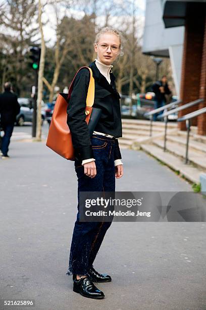 Danish model Frederikke Sofie wears large-frame glasses, a J.W. Anderson top, carries a Celine twisted cabas bag, and wears handwoven Faustine...