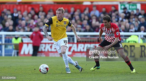 Nicky Adams of Northampton Town looks to move away with the ball watched by Craig Woodman of Exeter City during the Sky Bet League Two match between...