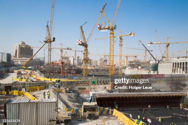 cranes and workers at construction site near souq waqif - qatar building stock pictures, royalty-free photos & images