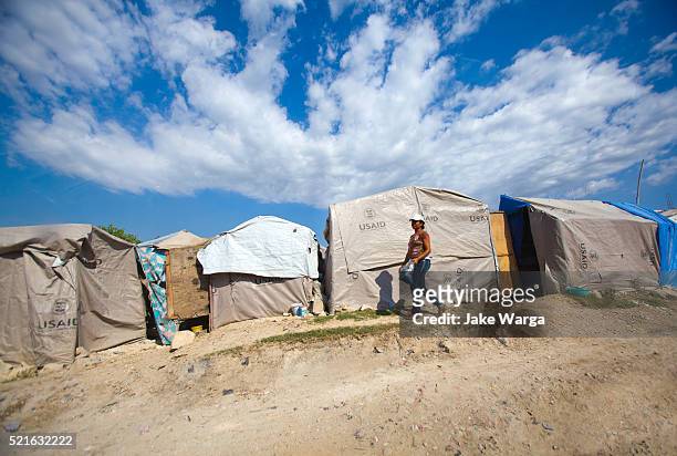 woman walking along tent camp in port-au-prince - jake warga stock pictures, royalty-free photos & images