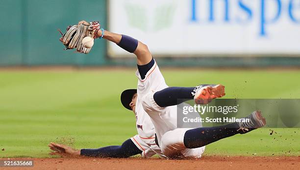Carlos Correa of the Houston Astros dives for a baseball in the infield during the third inning of their game against the Detroit Tigers at Minute...