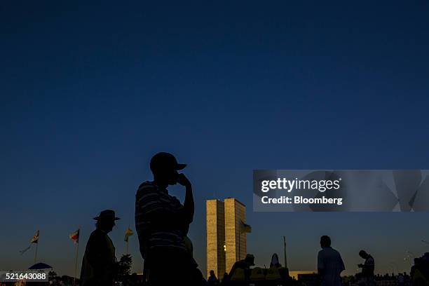 The silhouettes of protesters are seen standing outside of Congress during a demonstration against Dilma Rousseff, Brazil's president, in Brasilia,...