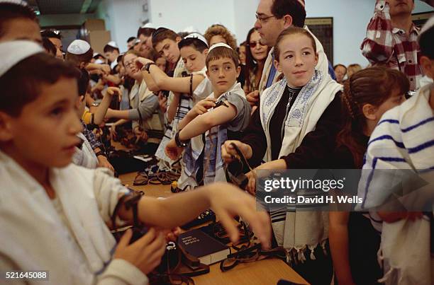 bar and bat mitzvah students putting on phylacteries - tefillin foto e immagini stock