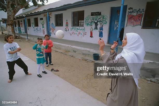 children and teacher playing in schoolyard - united nations relief and works agency for palestine refugees stock pictures, royalty-free photos & images