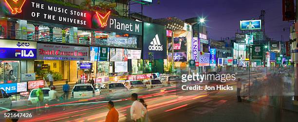 stores on brigade road at night - medium group of people stock pictures, royalty-free photos & images