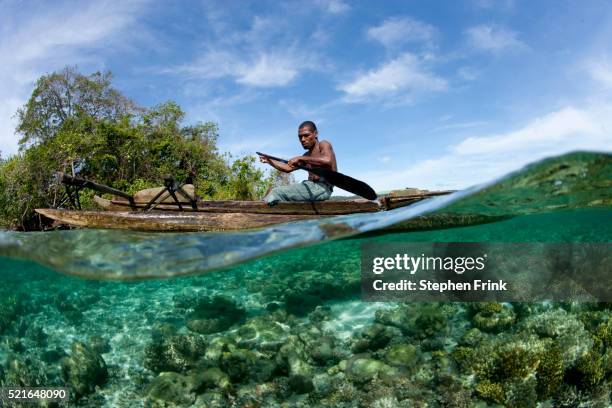 papua new guinea native in dugout canoe - einbaum stock-fotos und bilder