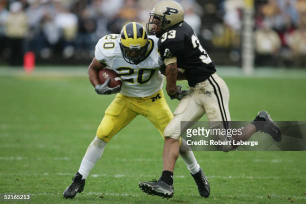 Running back Michael Hart of the Michigan University Wolverines gets tackled by cornerback Brian Hickman of the Purdue University Boilermakers during...