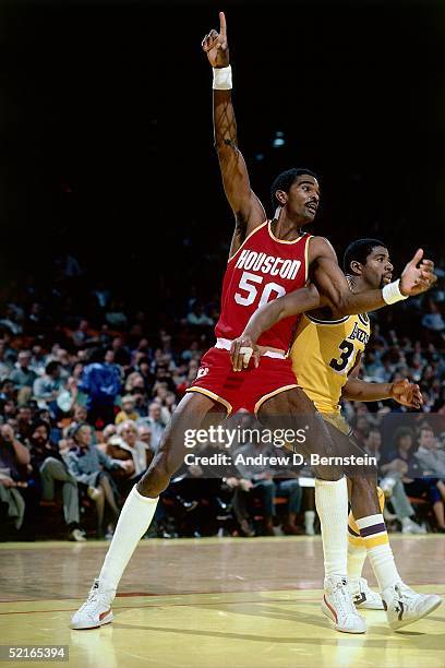 Ralph Sampson of the Houston Rockets post up against Magic Johnson of the Los Angeles Lakers during an NBA game at the the Forum circa 1986 in Los...