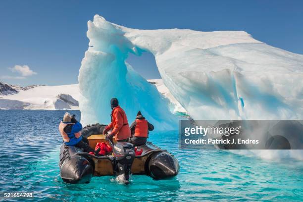 tourists view giant icebergs - iceberg stock photos et images de collection