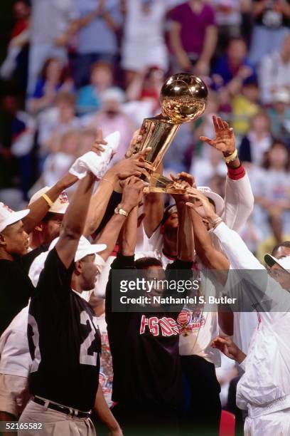 Isiah Thomas of the Detroit Pistons celebrates on the court with his teammates as they hold up the NBA Championship trophy after winning the Game...