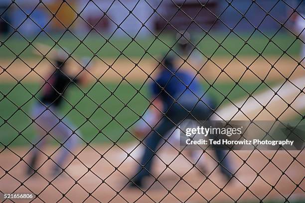 out of focus baseball game through fence - sports field fence stock pictures, royalty-free photos & images